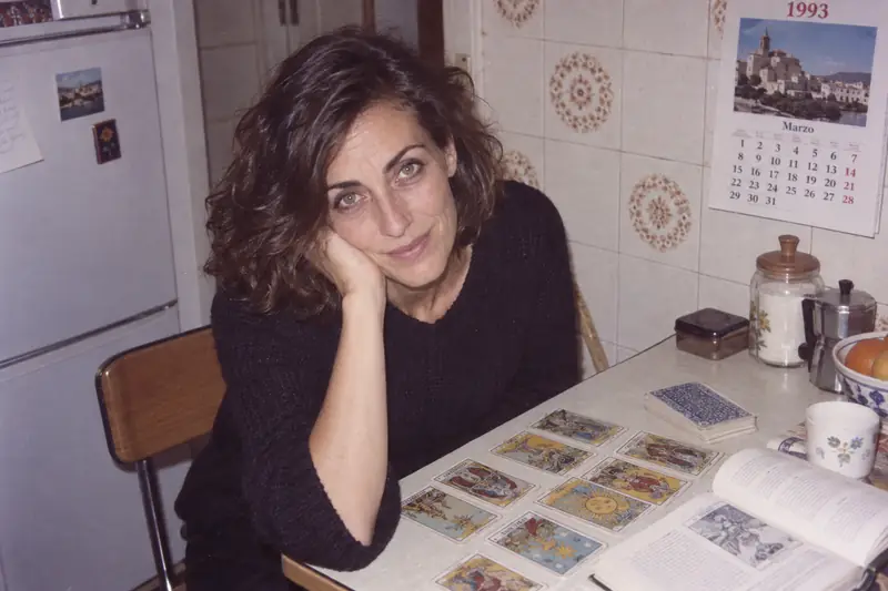 Fotografía de archivo de 1993: Trinidad con veinticuatro años, sentada a una mesa de cocina con las cartas extendidas y un manual abierto
